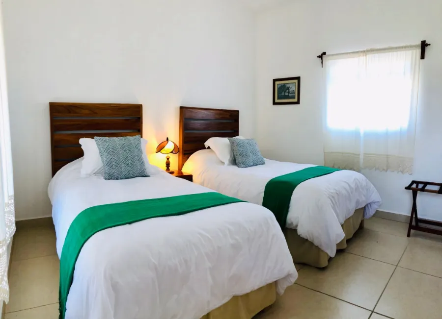 Habitación con dos camas individuales y colchas verdes
