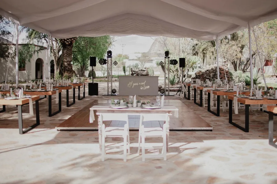 Montaje de un evento con mesas bajo carpa en el jardín